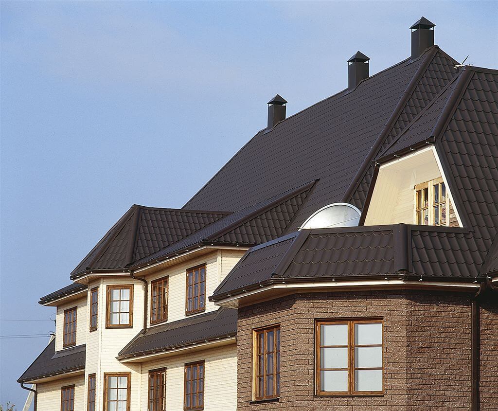 Modernes Wohnhaus mit schwarzem Pfannenblech-Dach – langlebig, witterungsbeständig und optisch ansprechend im klassischen Ziegeldesign.
