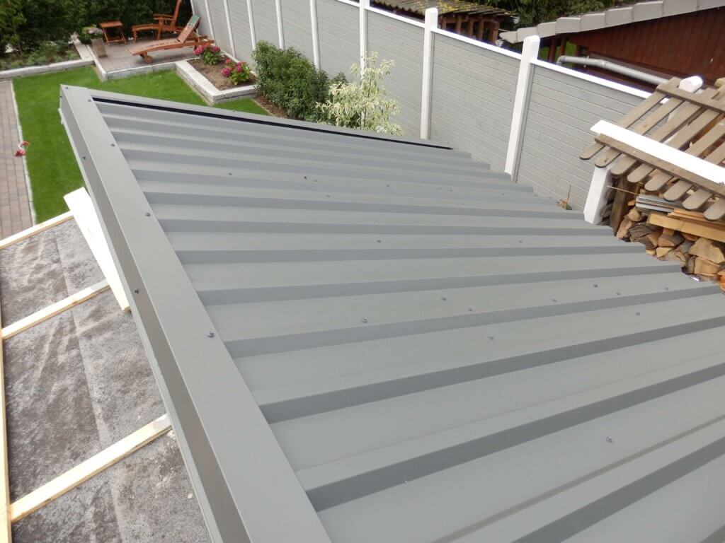 Zusehen ist ein graues Carportdach mit einer Eindeckung aus Trapezblechen.