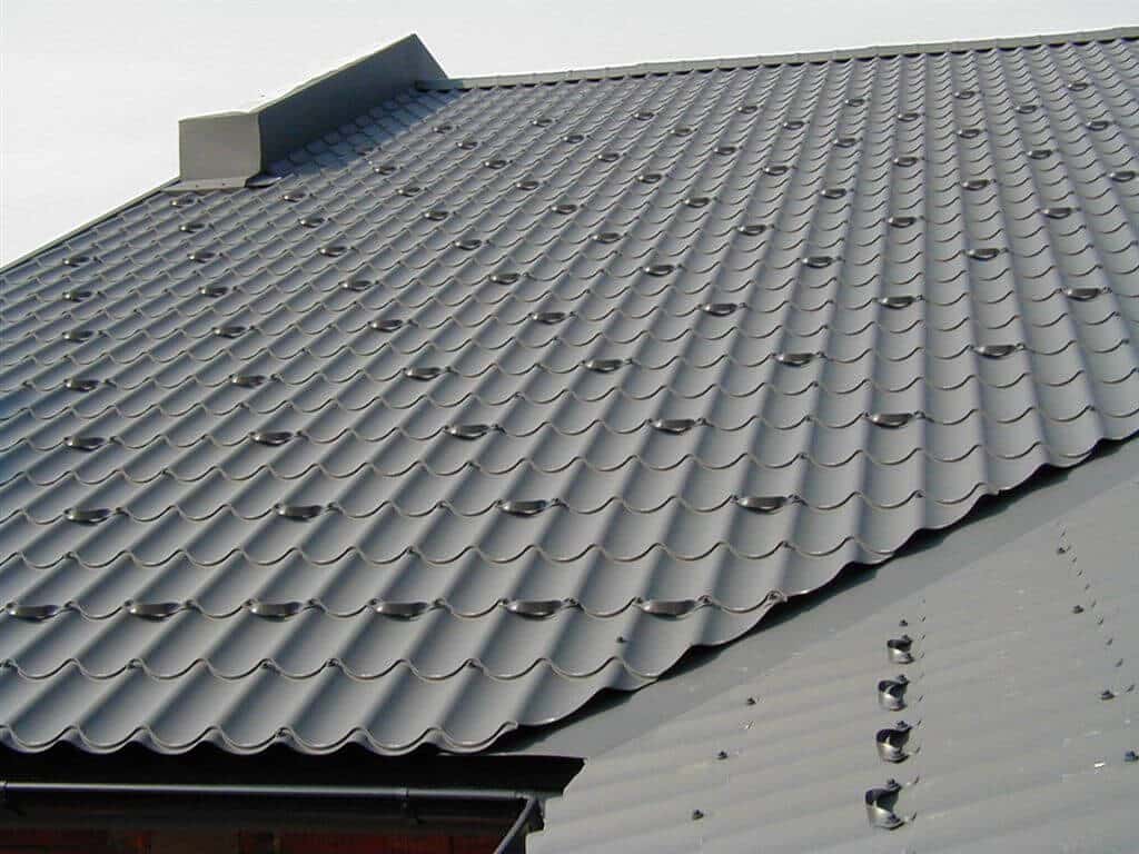 Dach mit dunkelgrauen Pfannenblechen aus Metall, sauber verlegt mit sichtbaren Befestigungsschrauben.