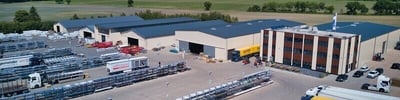 Effiziente Logistik für Baumaterialien Luftaufnahme eines Logistikzentrums mit gelagerten Baumaterialien und Lieferfahrzeugen