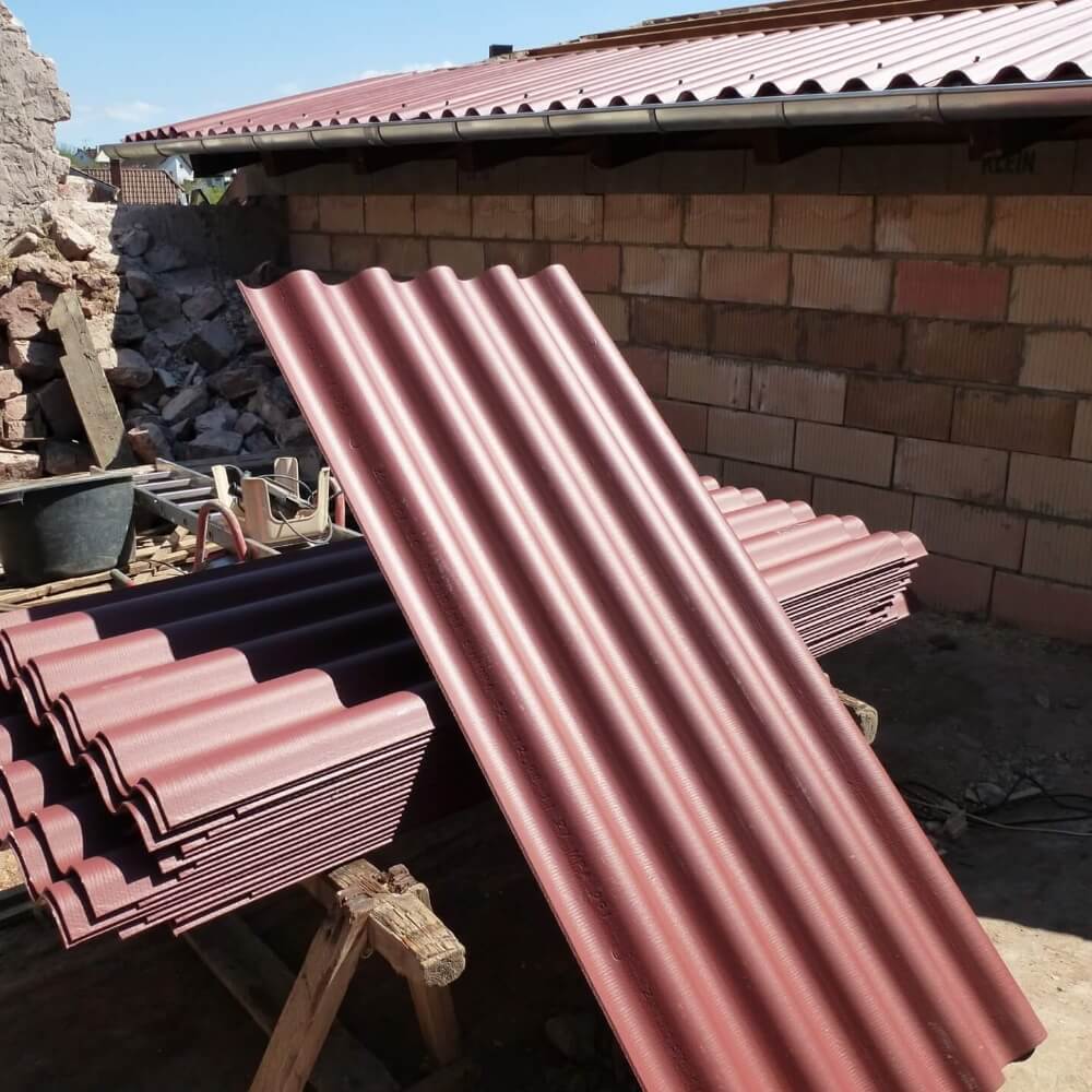 Stapel frischer Faserzement Wellplatten Stapel roter Faserzement Wellplatten bereit zur Montage auf Baustelle
